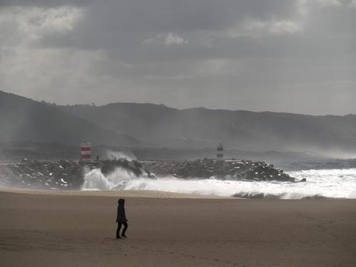 Regen und Herbststurm in Nazare, Spaziergängerin