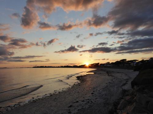 Sonnenuntergang und spielerische Wolken in der Bretagne am Atlantik (quer)