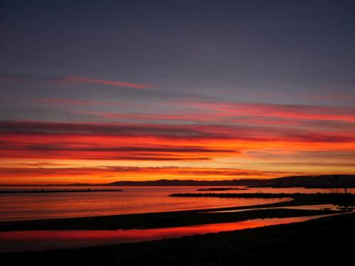 Farbiger Streifenhimmel mit Spiegelung im Meer in Nizza