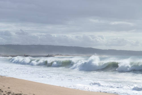 Weißwasser, Welle in der Bucht von Nazare mit Blick auf den Hafen